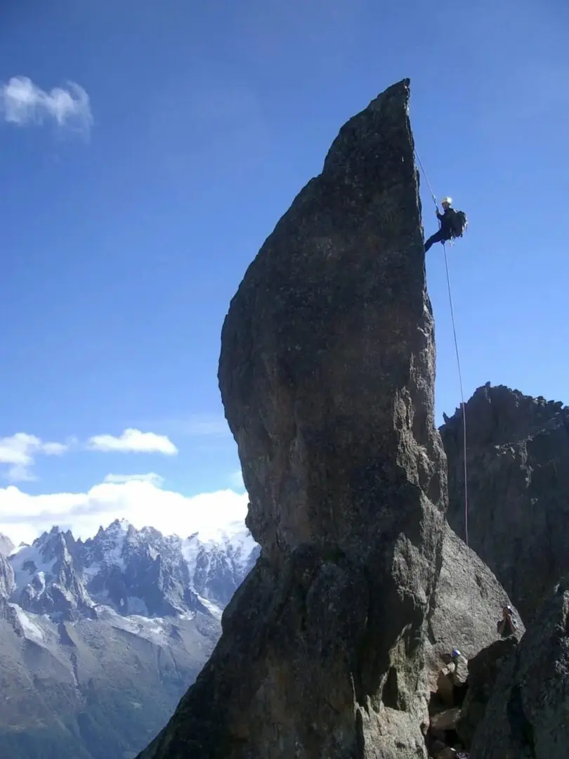 A person on a rock climbing route in the mountains.