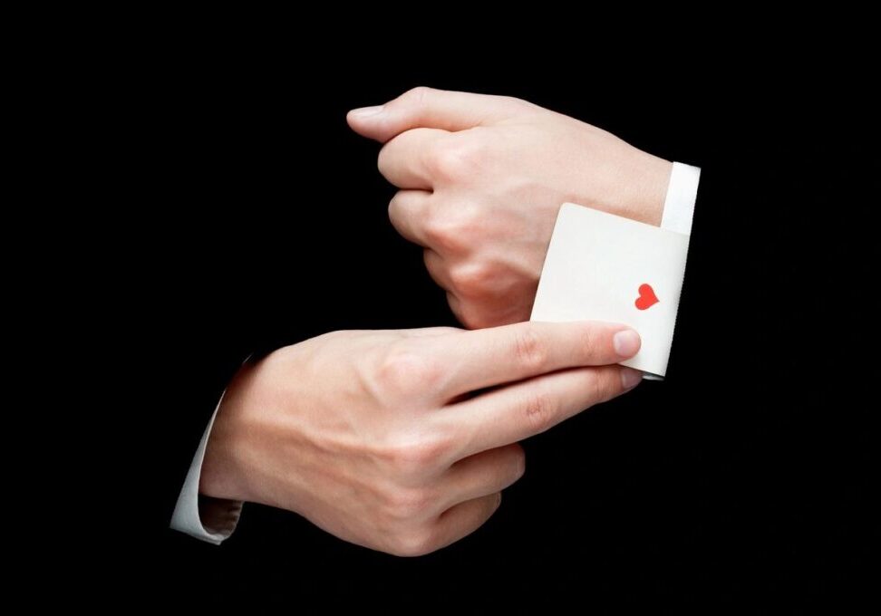 A person holding an ace of hearts card in their hands.